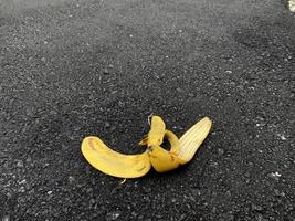 zicht op een bananenschil op de asfaltweg, wachtend tot iemand uitglijdt foto