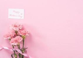 mooie verse bloeiende baby roze kleur tedere anjers geïsoleerd op fel roze achtergrond, Moederdag bedankt ontwerpconcept, bovenaanzicht, plat lag, kopieer ruimte, close-up, mock up foto