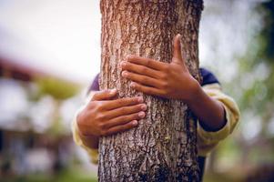 de foto heeft de bomen omarmd van jonge mannen die van de natuur houden. natuurlijk verzorgingsconcept