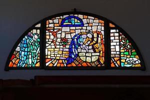 cannigione, sardinië, italië, 2015. glas in lood raam kerk van st. johannes de doper in cannigione foto