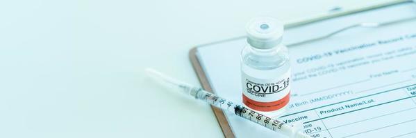 coronavirus 2019-ncov of covid-19 vaccin en medische naald op het covid-19 vaccinatierecord. foto