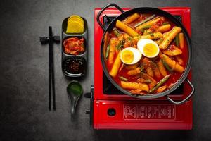 cheesy tokbokki koreaanse traditionele gerechten op zwarte bord achtergrond. lunchgerecht. foto