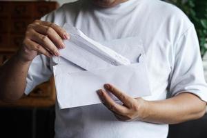 man trek de financiële ontvangst van de brief en lees het. foto