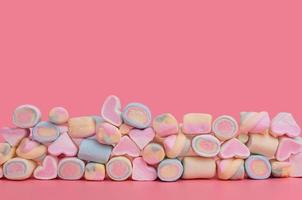 veelkleurige diverse marshmallows in verschillende rijen op een roze achtergrond foto