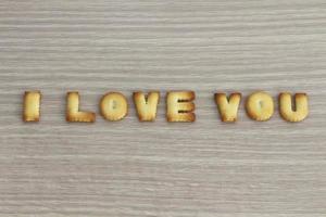 ik hou van je zin gearrangeerd met cookies abc op witte eiken houten achtergrond voor Valentijnsdag. foto