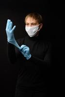arts die beschermende latexhandschoenen en gezichtsmasker draagt. vooraanzicht van iemands gezicht met een medisch masker. coronavirus covid-19 en zorgconcept foto