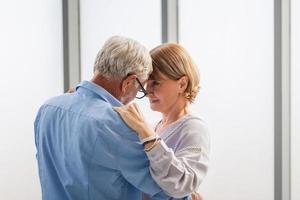 senior paar dansen in woonkamer, oudere vrouw en een man dansen, gelukkige familie concepten foto