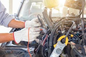 automonteur bezig met automotor in mechanica garage, reparatie en onderhoudsservice foto
