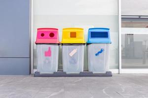 groep kleurrijke prullenbakken, verschillende gekleurde bakken voor het inzamelen van gerecyclede materialen. vuilnisbakken met vuilniszakken. milieu en afvalbeheerconcept. foto