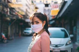 gelukkige aziatische volwassen vrouw tan huid draag masker op gezicht voor nieuw normaal. foto