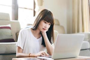aziatische tienervrouw werkt en studeert online via internet thuis. foto