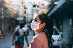 aziatische volwassen vrouw tan huid draag masker op gezicht voor nieuw normaal. foto