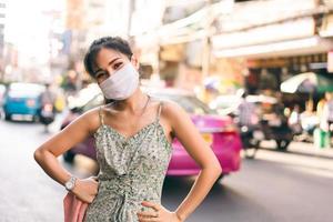 gelukkige aziatische volwassen vrouw tan huid draag masker op gezicht voor nieuw normaal. foto