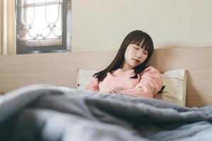 jonge Aziatische schattige tienervrouw slaapt 's ochtends in de slaapkamer foto
