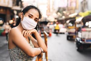 gelukkige aziatische volwassen vrouw tan huid draag masker op gezicht voor nieuw normaal. foto
