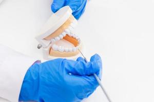 de tandarts introduceert de kennis met kunstgebitapparatuur in de tandheelkundige kliniek op tafel. foto