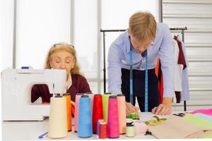 professionele teamwerkontwerpers, jonge mannen en oudere vrouwen op kantoor met een verscheidenheid aan stoftinten en apparatuur voor verschillende ontwerpen. foto