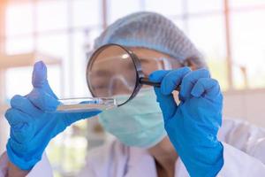 een Aziatische vrouwelijke wetenschapper onderzoekt een chemische formule in een laboratorium. foto