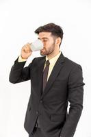 een knappe zakenman die zich over een koffie bevindt die op witte achtergrond wordt geïsoleerd, foto