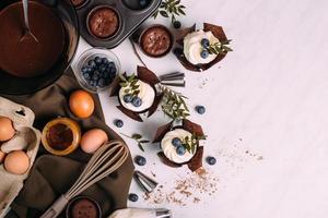 cupcakes met room en bosbessen op keukentafel foto