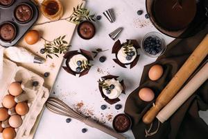 cupcakes met room en bosbessen op keukentafel foto