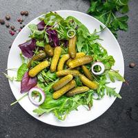 salade augurken ingelegde komkommers zoute groene blaadjes mix vegan of vegetarisch foto