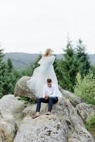 fotoshoot van een verliefd stel in de bergen. het meisje is gekleed als een bruid in een trouwjurk. foto