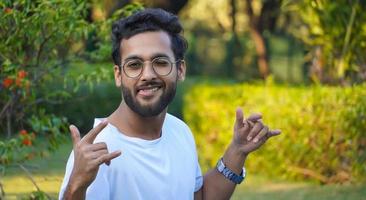 Indiase jonge knappe man geniet in het park buiten shoot foto