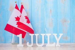 houten kalender van 1 juli met miniatuur canada vlaggen. Canada Day en gelukkige vieringsconcepten foto
