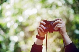 hand en camera van de fotograaf reizen in de bergen en natuurconcept fotograaf foto