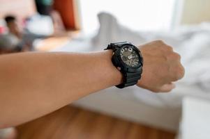 wijzers en zwarte horloges van jonge mannen die houden van horloges met tijdconcept foto