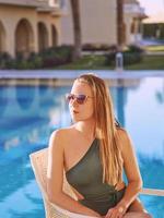 mooie vrouw chillen bij het zwembad. zomer, recreatie, reisconcept foto