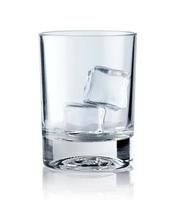 ijsblokjes in leeg glas op witte achtergrond. glas water of whisky en wijn. leeg glas voor alcoholische dranken foto