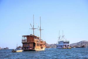 verschillende traditionele houten boot drijvend op de zee in de buurt van een eiland in Labuan Bajo foto