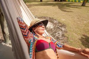vrouw in de buurt van het strand in caraiva, brazilië ontspannen in een hangmat in badkleding foto