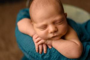 mooie pasgeboren baby die haar handen op haar gezicht rust foto
