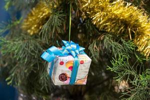 kerstdecor op geschenkdoos, linten en dennenboom foto