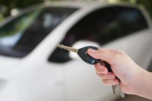 vrouwenhanddrukken op de autoalarmsystemen met afstandsbediening foto