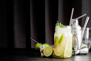 frisse zomerse caipirinha-cocktail op een zwarte gordijnachtergrond foto