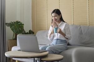 jonge mooie vrouw werkt thuis met haar computer. foto