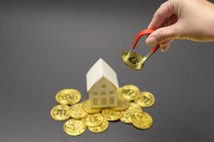 kleine witte modelwoning met cryptocurrency bitcoin, bitcoin mining en financieel concept foto