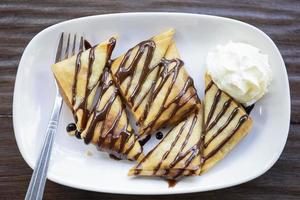 bananen samosa's gegarneerd met chocolade slagroom. foto