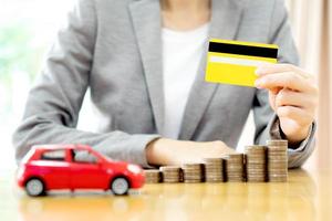 zakenvrouwen hand met creditcard en veel munten met auto foto