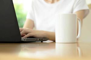 close up van een vrouw handen typen in een laptop in een koffieshop terras in de straat foto