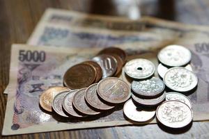 geïsoleerde Japanse valuta-yen met zijn Aziatische symbolen in de vorm van munten en bankbiljetten op de witte achtergrond foto