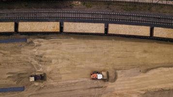 de lader laadt het zaagsel in de luchtfoto van de houtbewerkingsfabriek foto