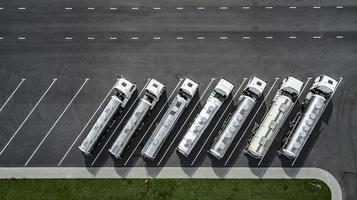 vrachtwagens staan in een rij op het bovenaanzicht van de parkeerplaats. logistiek centrum. foto