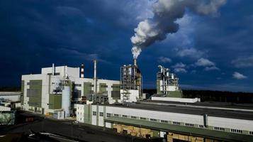 rook uit fabrieksschoorstenen tegen een donkere lucht luchtfotografie vanuit een drone foto