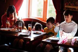 kinderen op verjaardagen aan tafel zitten en pizza eten. foto