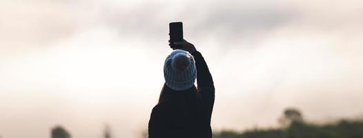 silhouet volwassen vrouw solo reiziger gebruik smartphone. foto